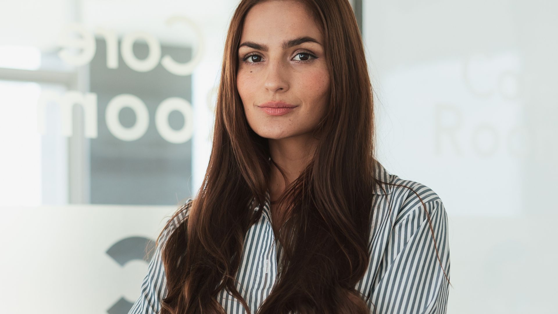 A Female Wearing Formal Clothing, Looking at Camera in an Office