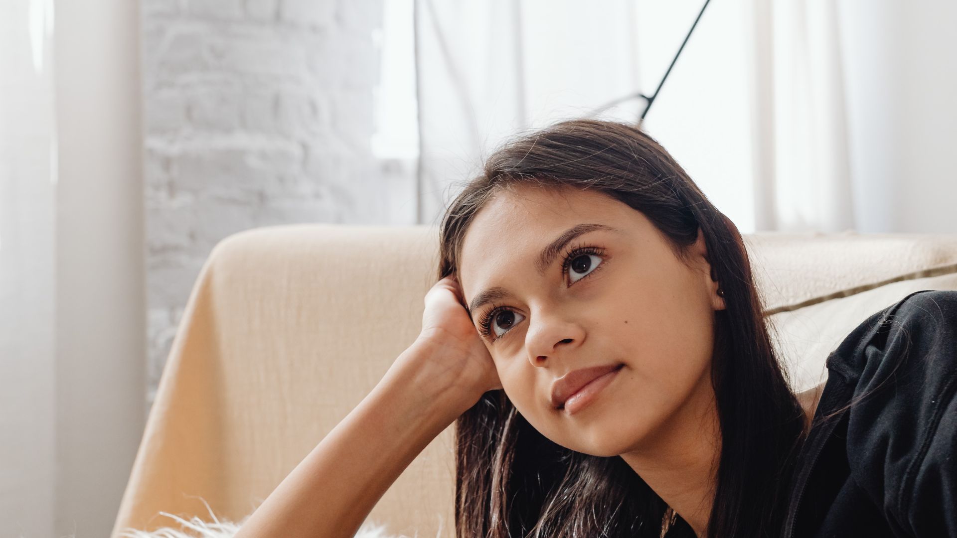 A Woman Watching while Holding a Remote Control