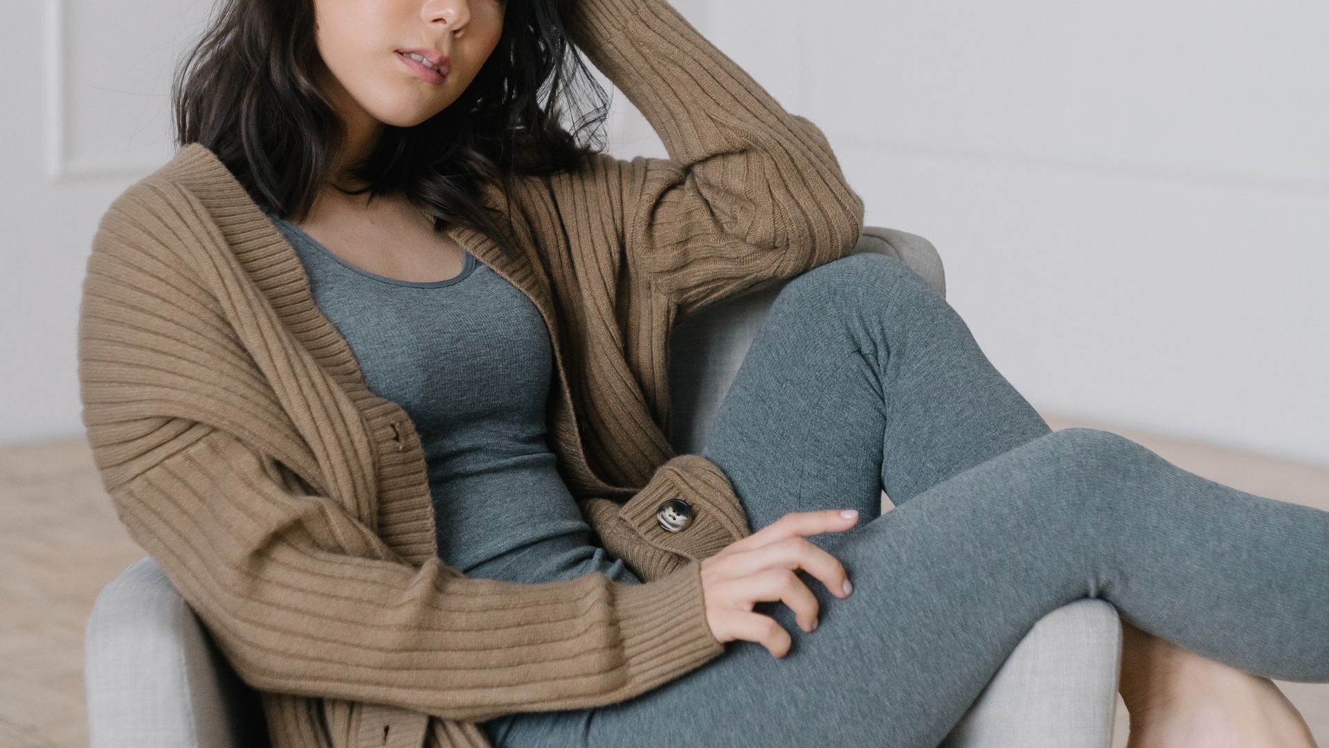 A Woman Wearing Cardigan Siting on Sofa Chair