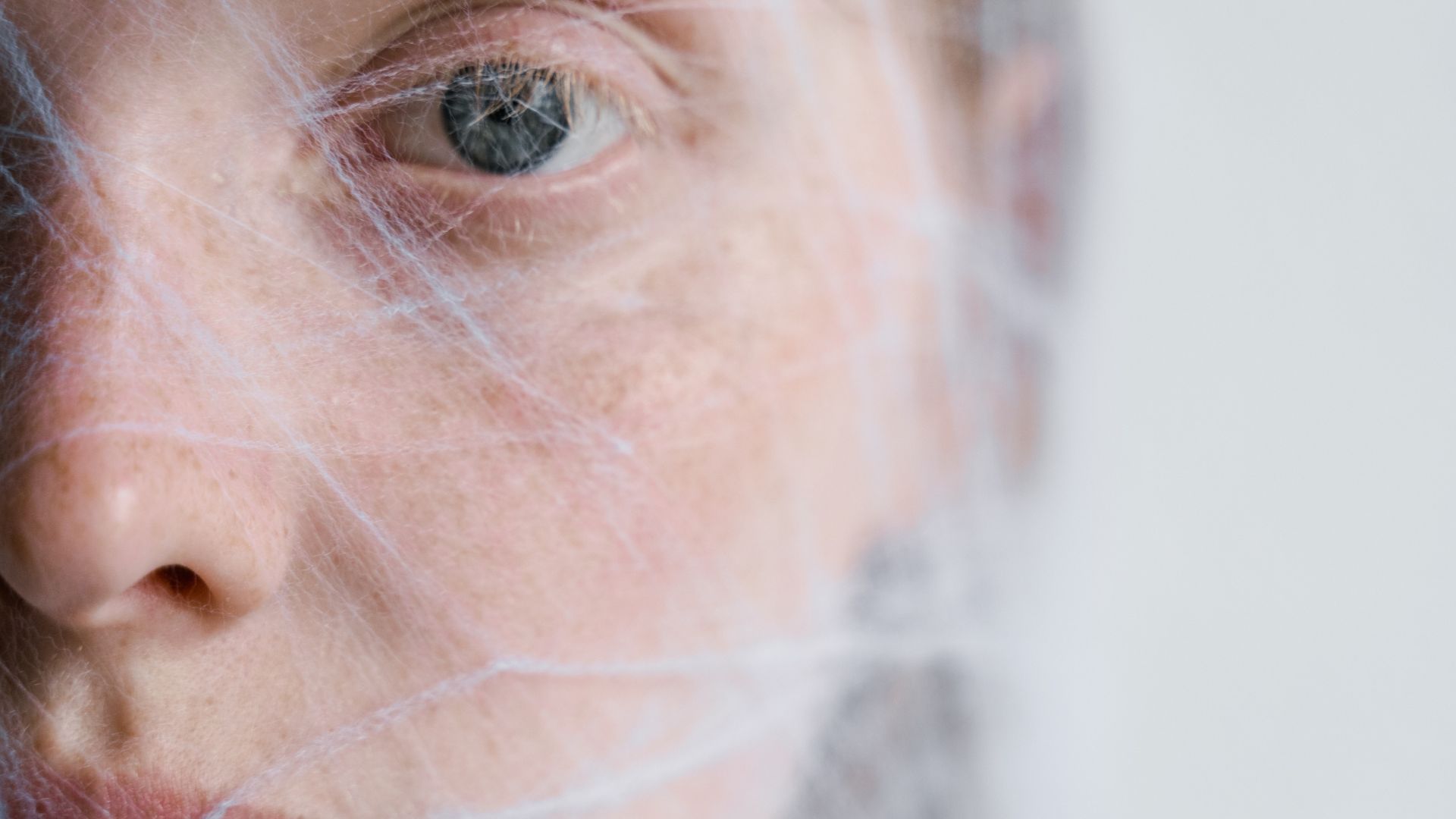 Close-Up Photo of a Helpless Woman Trapped in a Spider Web