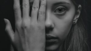 Grayscale Photo of Woman Covering Her Face by Her Hand