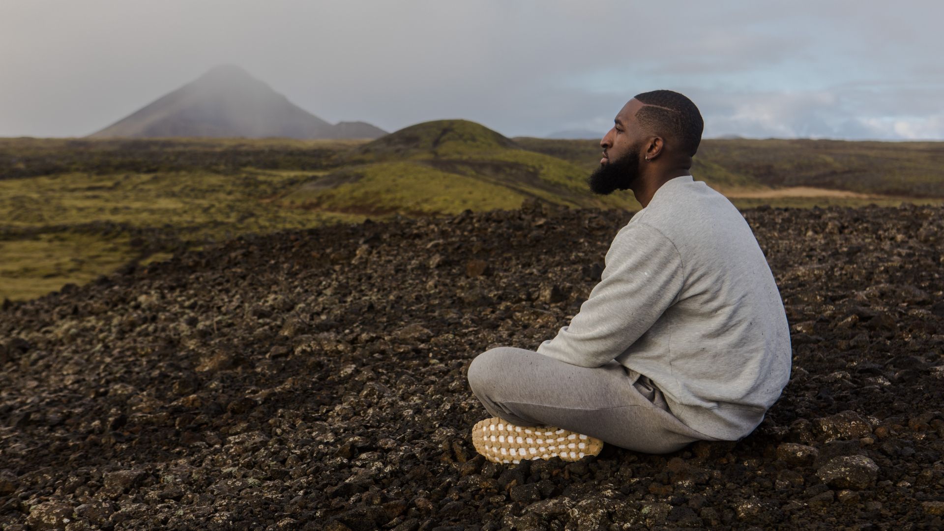 Man in White Top Sitting on Brown Soil