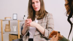 Pensive female coach talking with client in light room