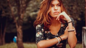 Pensive young woman dreaming in garden