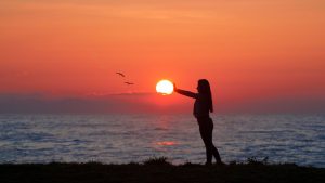 Photo of Woman Standing On Seashore During Dawn