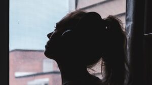 Silhouette Photo of a Woman Looking Through Window