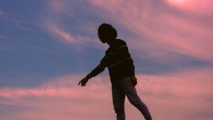 Silhouette of person against bright sunset sky