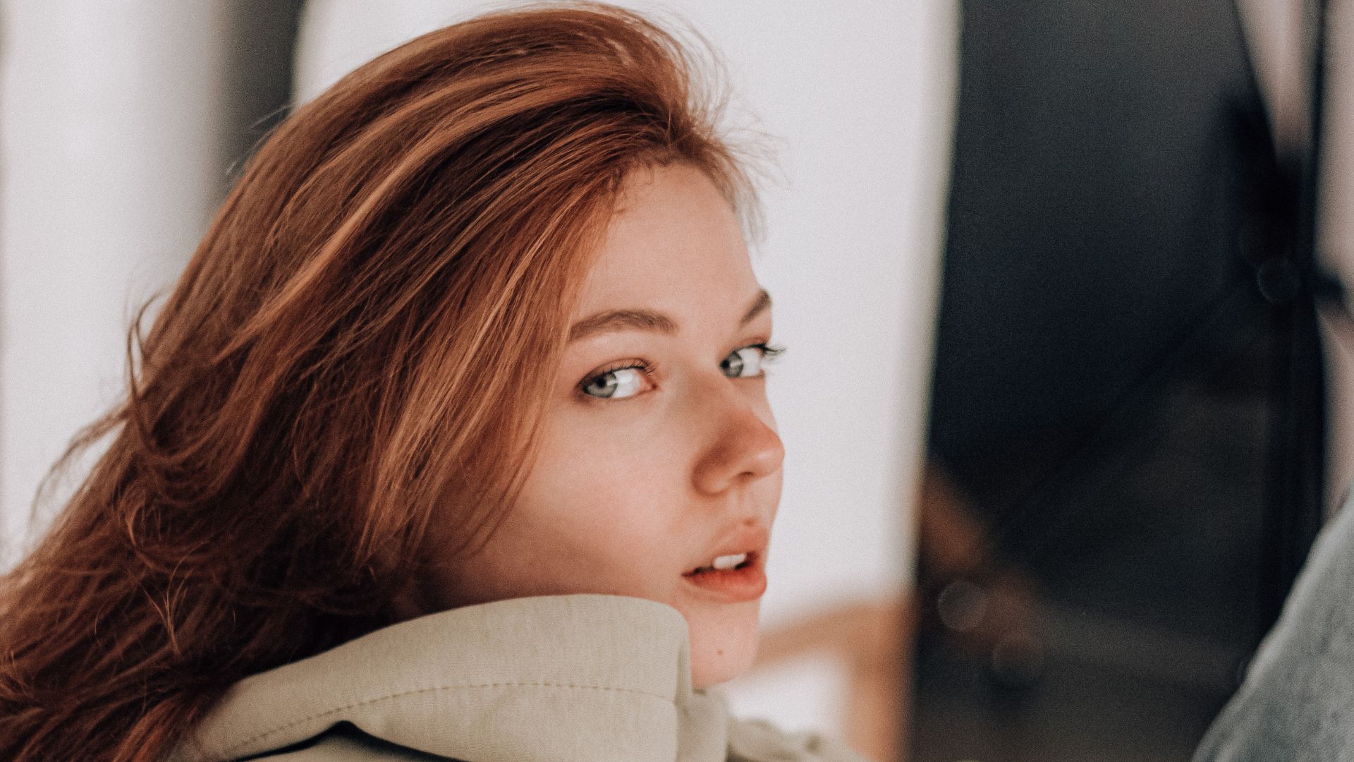 Stylish woman in beige hoodie sitting on chair