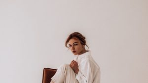 Stylish woman sitting on chair in studio