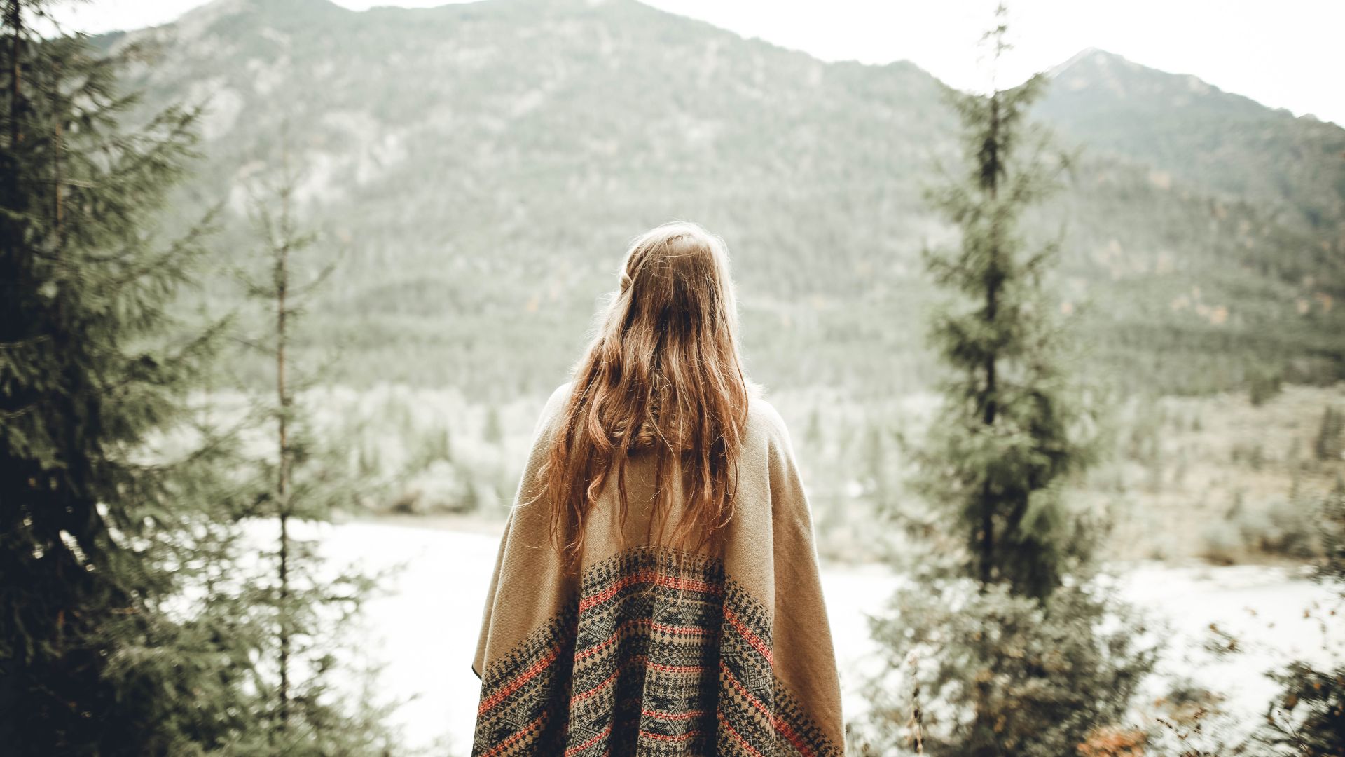 Woman Wearing Brown Poncho Facing Mountain