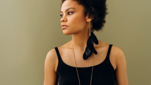 Woman in Black Tank Top Wearing Black Earbuds