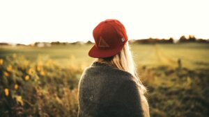 Woman in Gray Cardigan and Red Snapback Cap