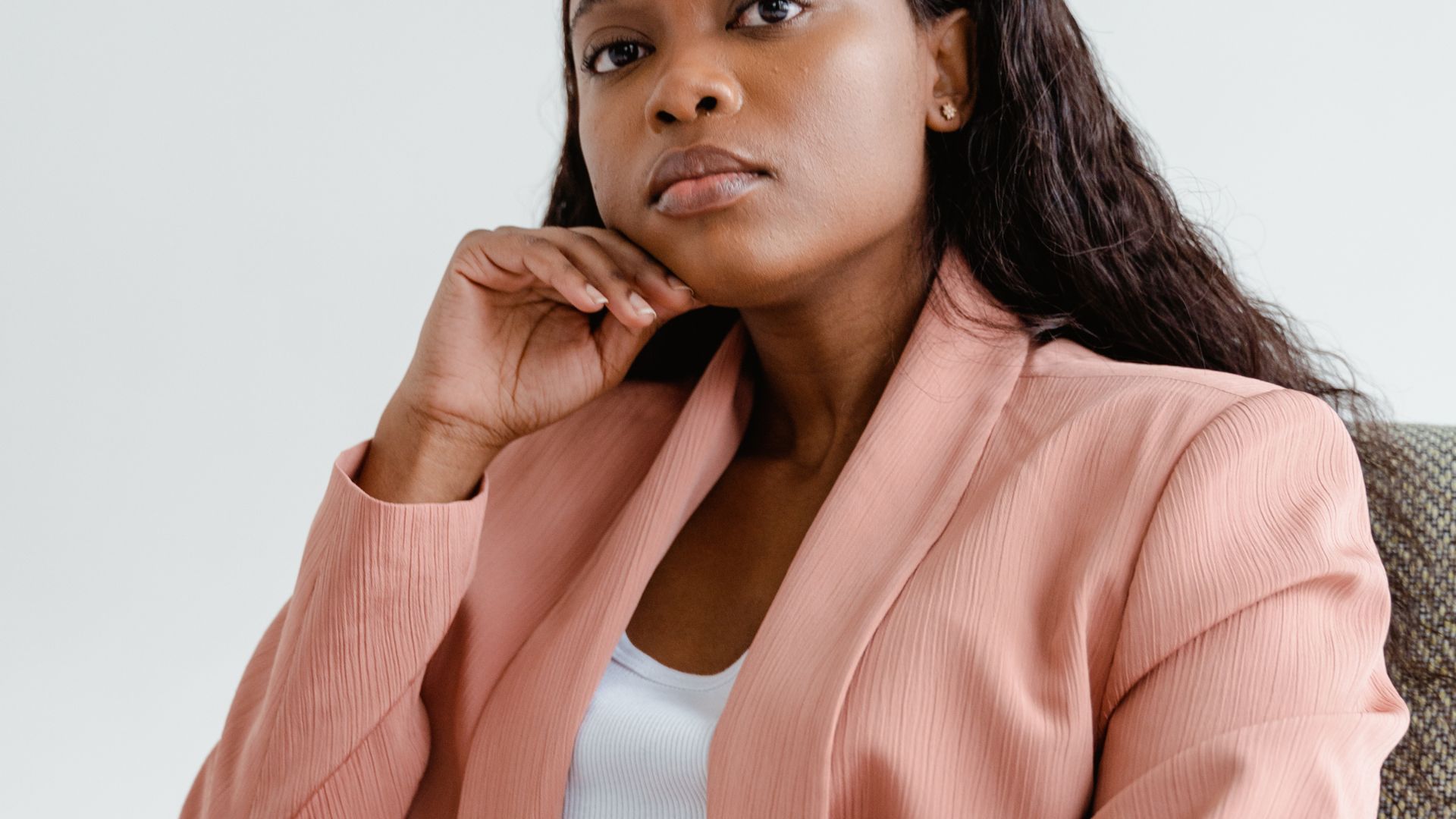 Woman in Pink Business Suit Sitting on Chair