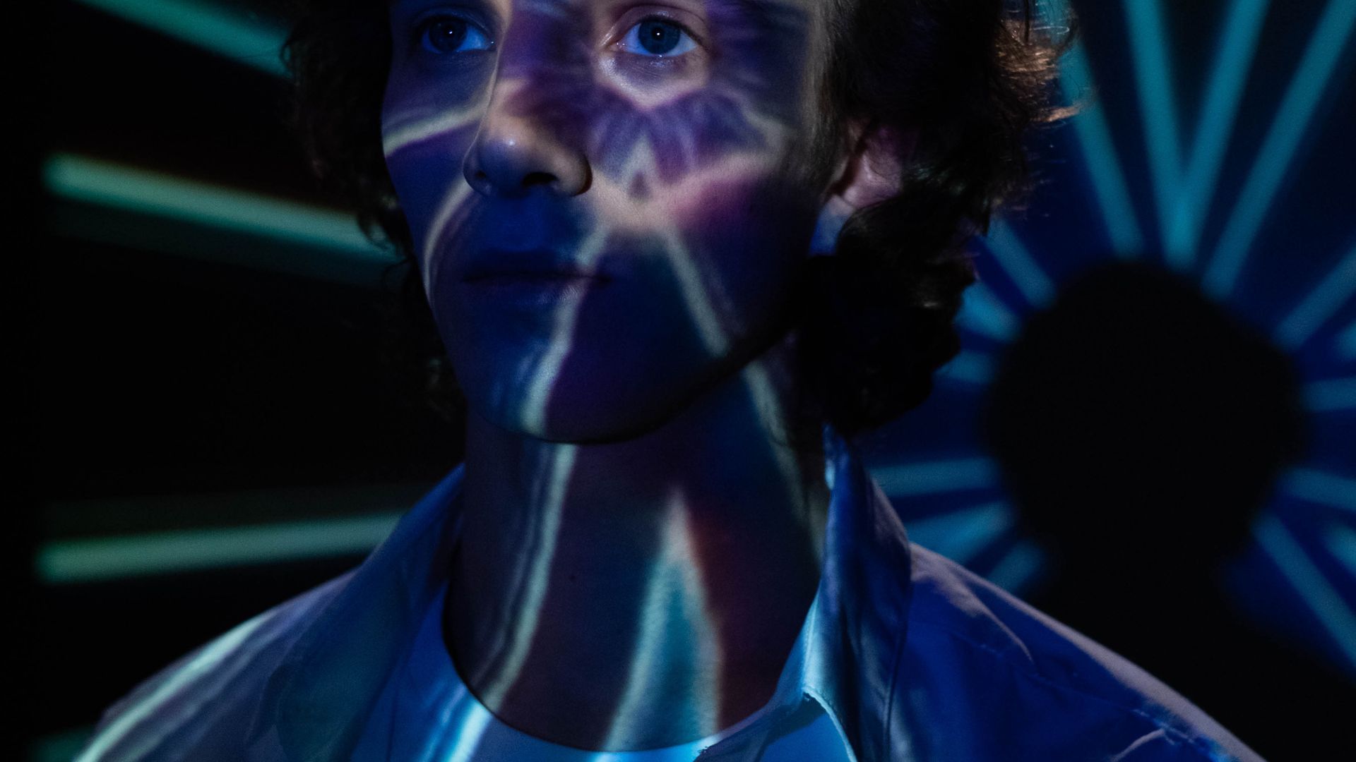 Man in Blue Crew Neck Shirt With Blue and Green Lights on His Face