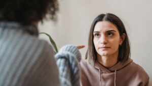 Women arguing while pointing finger in face at home