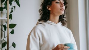 Young sad woman with mug of hot drink