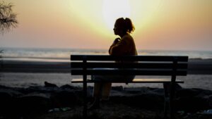 woman Sitting on Bench during Sunset